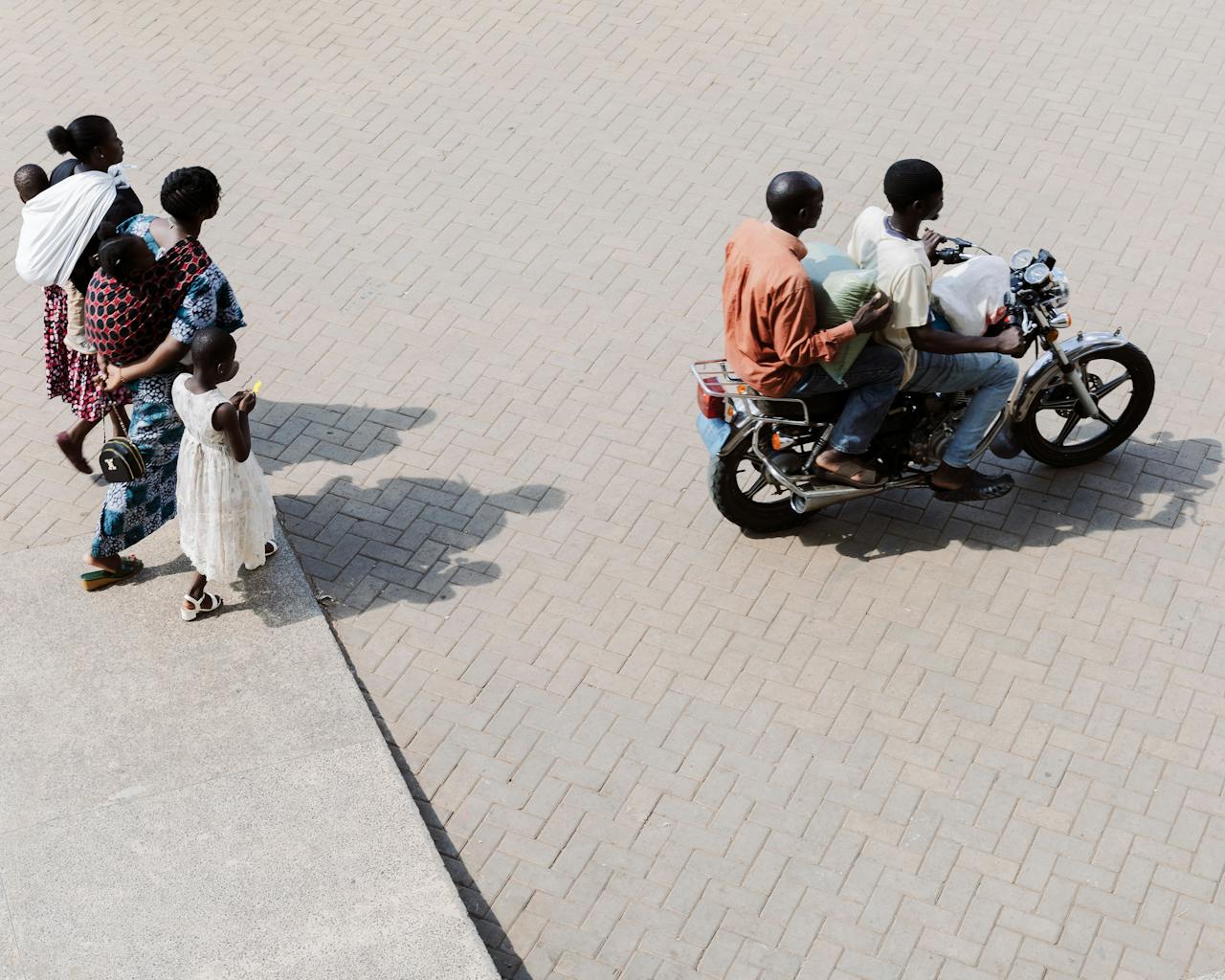 service-02 A typical day in Morogoro, Tanzania, showing families walking and motorbike riders.