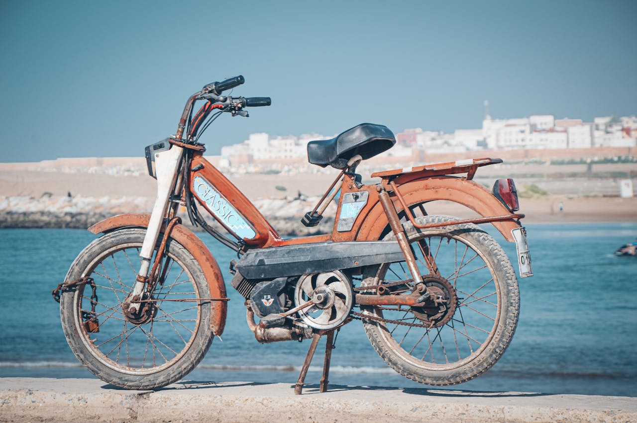 service-01 Vintage Peugeot moped parked by the sea in Rabat, Morocco.